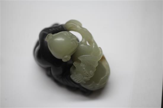 A Chinese pale celadon and dark grey jade and stand